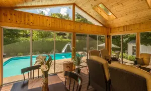 Porche de madera con vistas a piscina y tobogán. Ideal para aprender como hacer un porche de madera y disfrutar del verano.