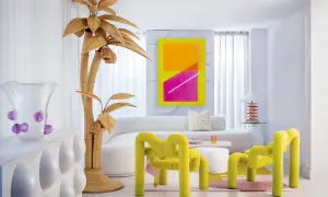 Sala de estar con vibrante arte abstracto, muebles curvos y un árbol de mimbre, todo con un audaz estilo Memphis.