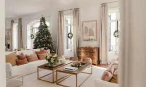 Un salón acogedor con un árbol de Navidad decorado, sofás cómodos y mesas de centro de madera. Es la casa de navidad de el mueble, lista para celebrar.