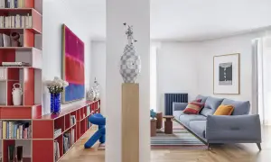 Estudios de arquitectura: sala de estar moderna con sofá azul, alfombra de rayas, estanterías rojas y arte abstracto.