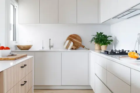 Cocinas modernas con encimeras blancas, armarios minimalistas y detalles en madera. Perfectas para un hogar contemporáneo.