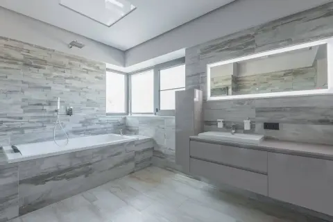 Modernos baños con bañera, lavabo y espejo iluminado. Inspiración para tus ideas baños.