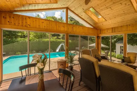 Porche de madera con vistas a piscina y tobogán. Ideal para aprender como hacer un porche de madera y disfrutar del verano.