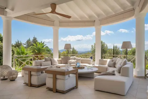 Cómodas terrazas modernas exterior con sofás modulares, sillones y mesa de centro, vistas a un paisaje verde y montañoso.