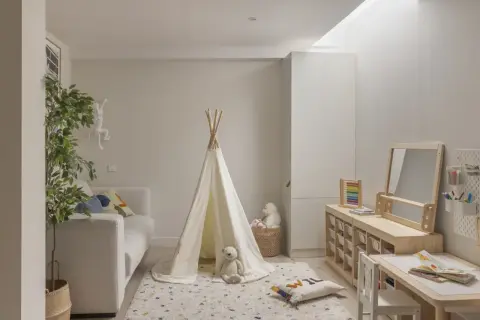 Ideas para un cuarto de juegos: tienda de campaña, sofá, alfombra, mesa de actividades y estanterías de madera.