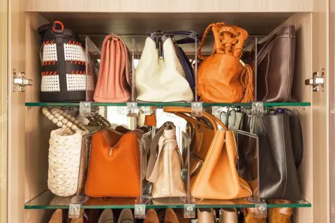 Estantería con varios bolsos de diferentes colores y estilos, perfectamente organizados para facilitar su acceso.