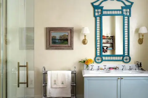Elegante baño sin azulejos, con lavabo doble, espejo azul y cuadro de paisaje.