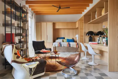Un espacio acogedor que demuestra cómo los **mini apartamentos** pueden ser funcionales y estilosos, con cama empotrada, zona de trabajo y cómodos asientos.