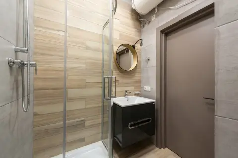 Modernos baños pequeños con ducha, lavabo flotante y espejo redondo.