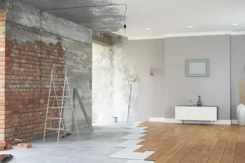 Renovación de casas con encanto: ladrillo visto, escalera, rodillo y suelo de madera en proceso.