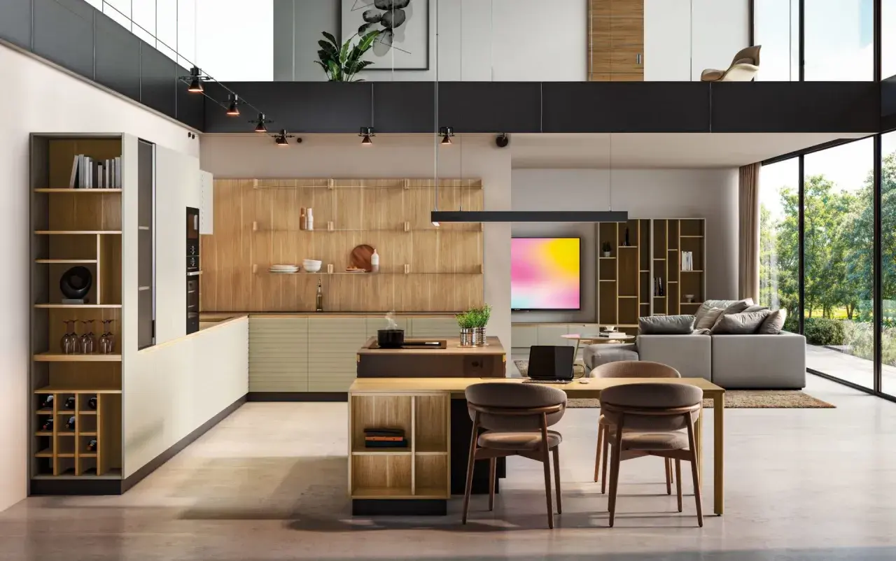 Moderna cocina con ventanal, estanterías de madera y una isla central. El espacio se abre a un salón con sofá y vistas al exterior.