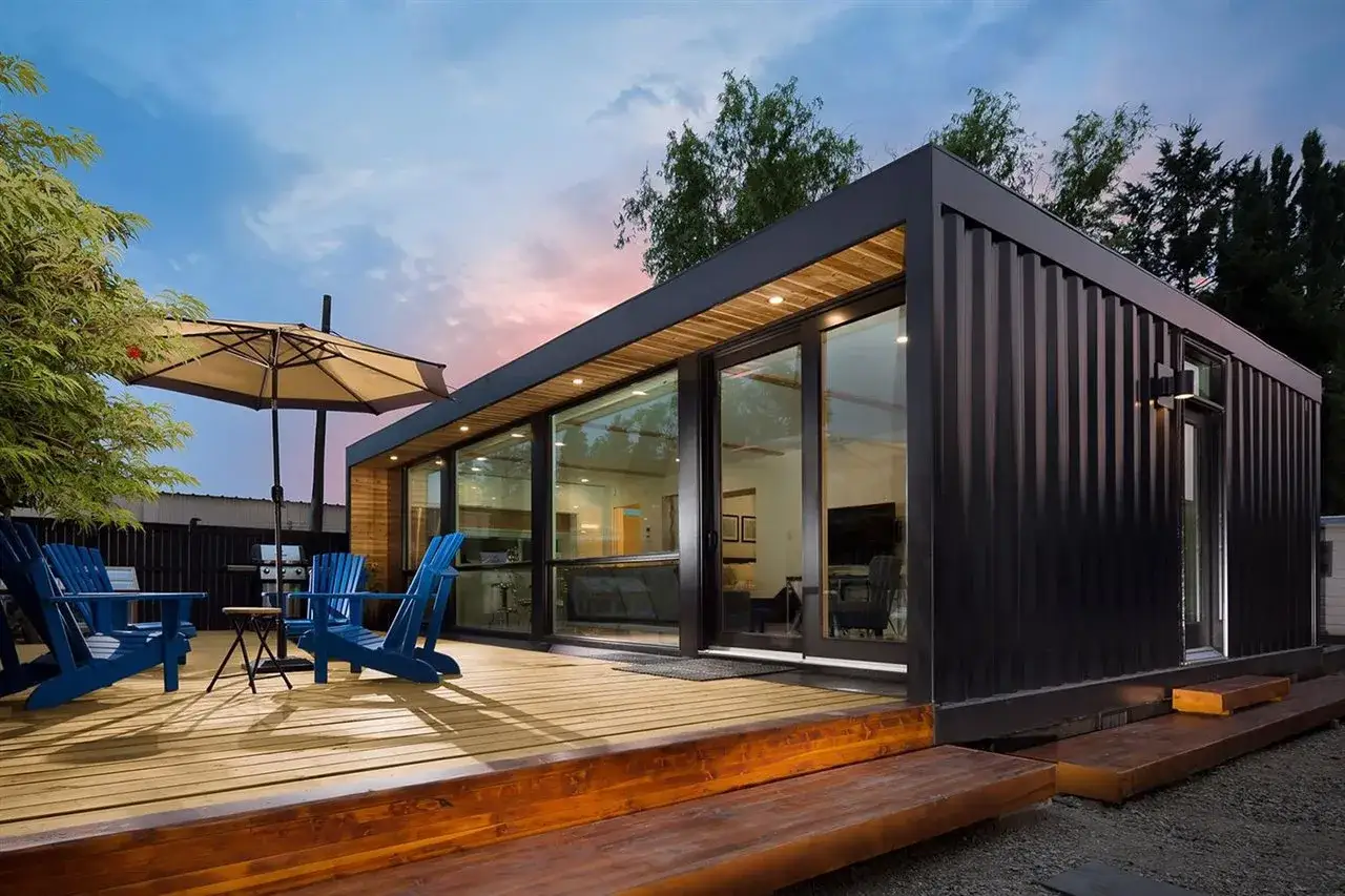 Modernas casas contenedores con terraza de madera y sillas azules. Un oasis de diseño y sostenibilidad.