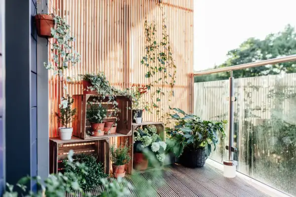 Ideas balcones muy pequeños: plantas en cajas de madera crean un oasis verde.