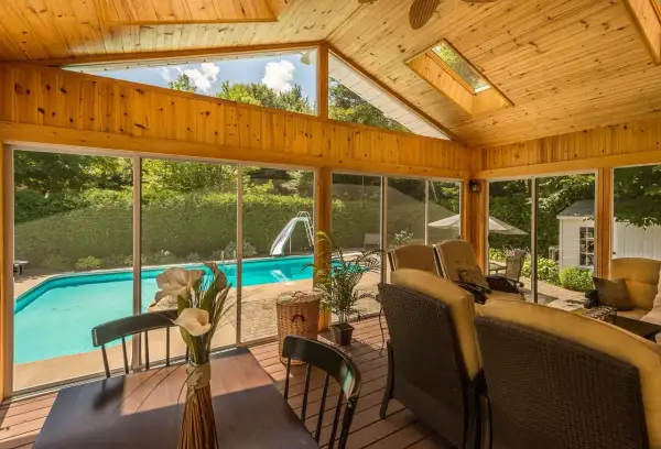 Porche de madera con vistas a piscina y tobogán. Ideal para aprender como hacer un porche de madera y disfrutar del verano.