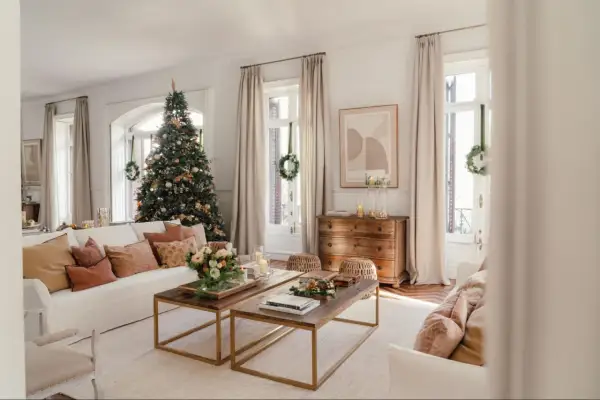 Un salón acogedor con un árbol de Navidad decorado, sofás cómodos y mesas de centro de madera. Es la casa de navidad de el mueble, lista para celebrar.