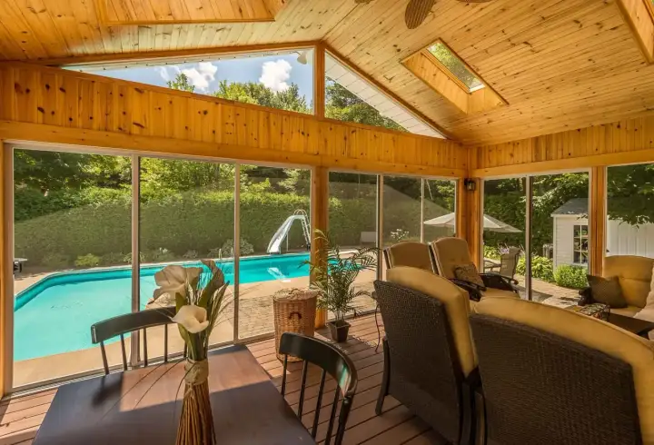 Porche de madera con vistas a piscina y tobogán. Ideal para aprender como hacer un porche de madera y disfrutar del verano.